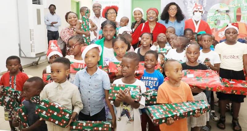 La marraine (en rouge) a posé avec les enfants heureux de recevoir des cadeaux.