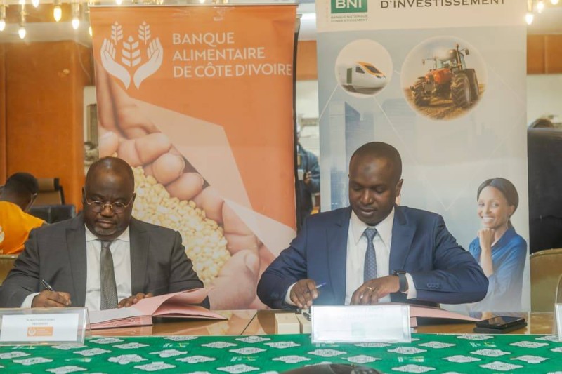 Les DG de la Bni (à droite) et celui de la Banque alimentaire signent chacun le document de la convention. (Photo Bavane)