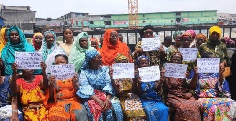 Des femmes commerçantes du marché Gouro d’Adjamé-Roxy manifestent avec des écriteaux, exigeant le remboursement de leurs souscriptions et l'achèvement des travaux du marché.