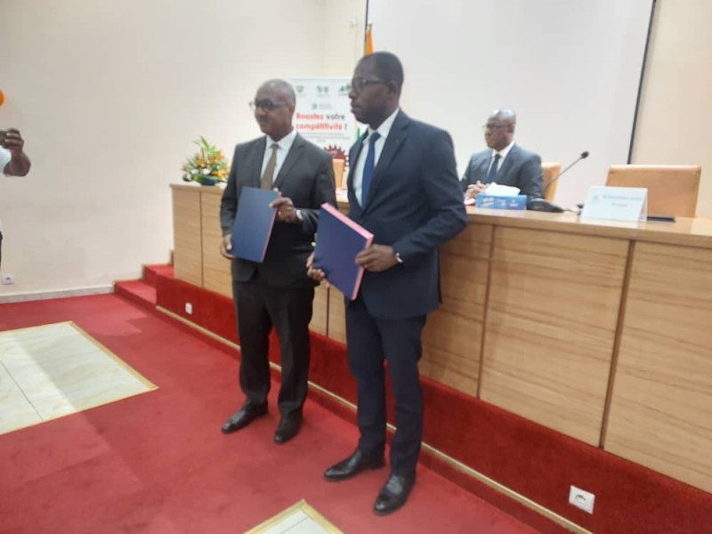  Échange de parapheurs entre le directeur général par intérim de l'Adci, Éric Ouattara et le président de l'Oii-CI, Hyacinthe Yapo. (DR)