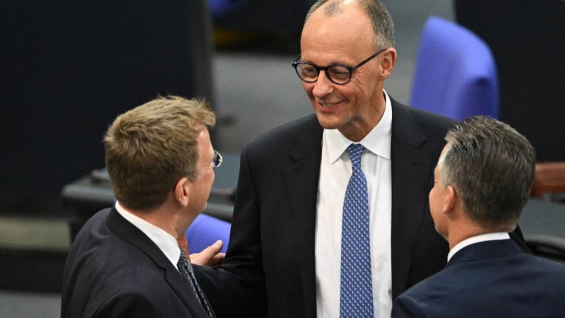 Le chancelier allemand désigné Friedrich Merz (au centre) s'entretient avec les délégués dans la salle plénière à leur arrivée pour la poursuite d'une session au Bundestag (chambre basse du parlement), alors que les députés doivent élire le prochain chancelier allemand, à Berlin le 6 mai 2025. AFP - RALF HIRSCHBERGER
