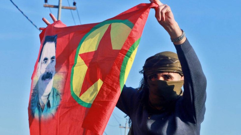Depuis plus de 40 ans, le PKK avait mené une lutte armée contre le pouvoir turc, pour obtenir l'indépendance du Kurdistan. Ici, une femme kurde agite un drapeau portant le portrait du fondateur du Parti des travailleurs du Kurdistan (PKK), Abdullah Öcalan, alors que des personnes se rassemblent au Freedom Park pour écouter un message audio du leader emprisonné. AFP - SHWAN MOHAMMED