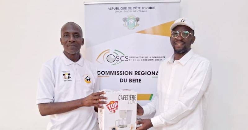 Hamed Dosso (à droite) cadeaute le proviseur du lycée moderne de Bonoua. (Ph: Dr)