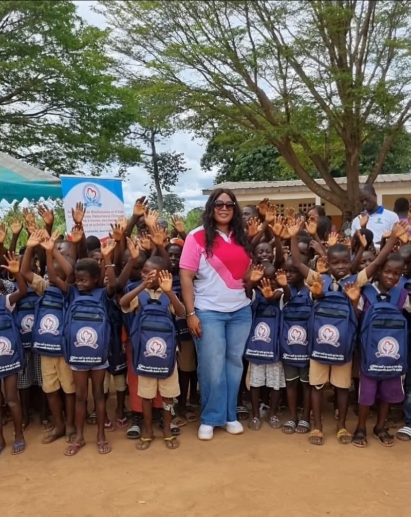 Mariam Stéphanie Fadiga posant avec les bénéficiaires de kits scolaires. (Ph: Dr)