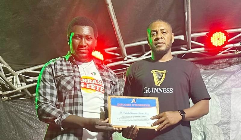 Faustin Ehouman (à gauche) recevant un diplôme d’honneur des mains du promoteur du festival, Claver Gballou. (Ph: Dr)
