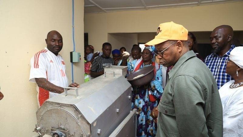 Le Minisitre Adama Kamara observant une unité de production d'attiéké
