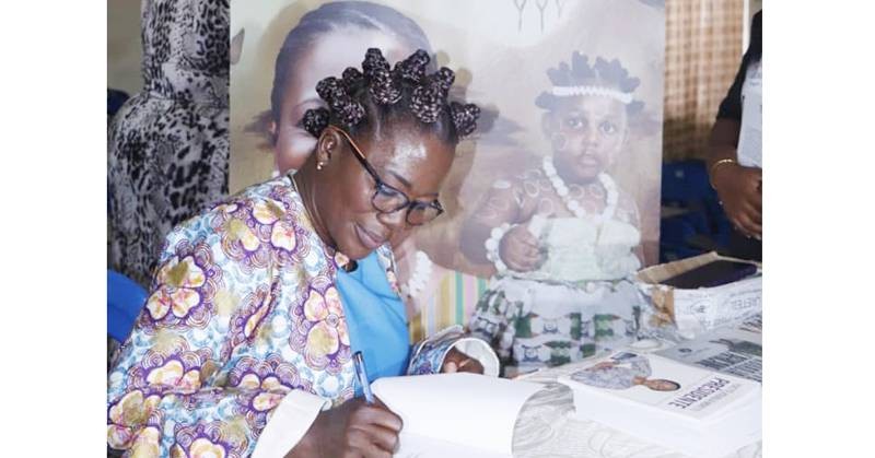 Brigith Gbadi, sociologue et écrivain, en train de dédicacer une de ses œuvres. (Ph: Dr)
