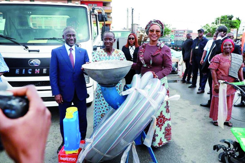 La ministre Nasseneba Touré remettant du matériel à une bénéficiaire, en présence d'Adama Bictogo.