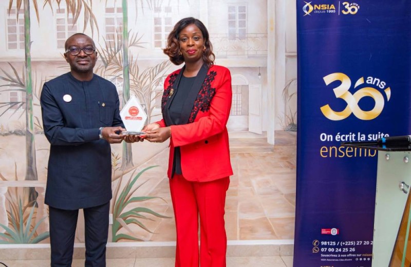 Le Dg recevant le trophée des mains de Manuella Ollo...