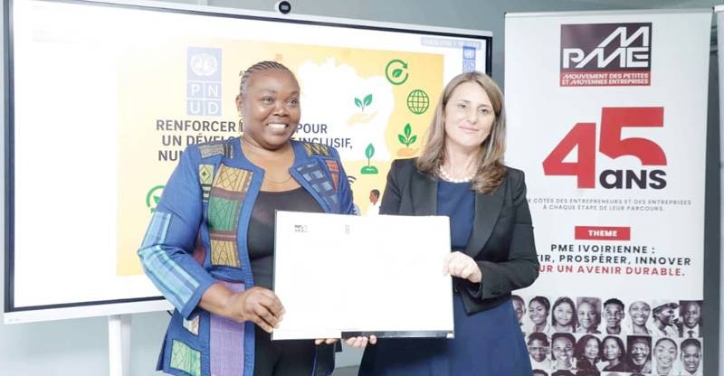 Patricia Zoundi Yao, présidente du Mpme (à gauche) et la Représentante résidente du Pnud, Blerta Cela, ont fièrement brandi le parapheur après l'avoir signé. (Ph: Dr)