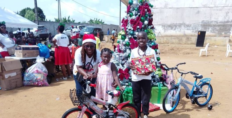 Des enfants heureux brandissant leurs cadeaux, symboles de solidarité et de partage en cette période de Noël.