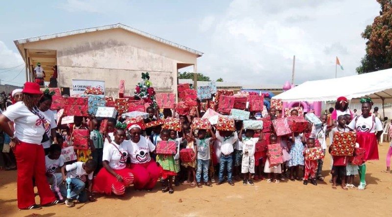 Des enfants d’Adiopodoumé, tout sourire, recevant leurs cadeaux de Noël lors de la 15ᵉ édition de la Caravane du Bonheur.