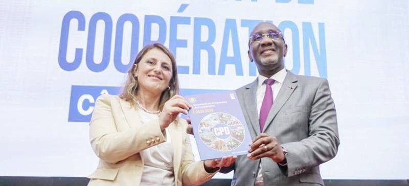 La Représentante pays du Pnud en Côte d'Ivoire et le ministre du Plan et Développement, présentant fièrement les parapheurs du nouveau programme.