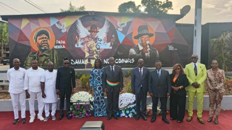 En fond, la fresque murale qui témoigne désormais de la présence  du génie de la Rumba à Anoumabo (JD)