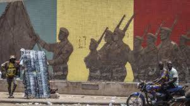 Un motard passant devant un monument en soutien à l'armée malienne à Bamako, le 26 avril 2026. AFP - -