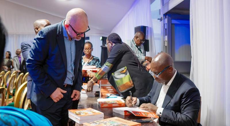 Jean-Louis Menann-Kouamé (assis) a laissé de petits mots sympas dans les ouvrages de ses premiers lecteurs. (Ph: Dr)