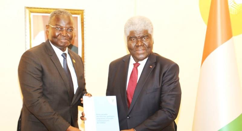 Le Premier ministre Robert Beugré Mambé, recevant le livre des recommandations des mains du président Abdoulaye Diop. (Ph: ABDOULAYE COULIBALY)